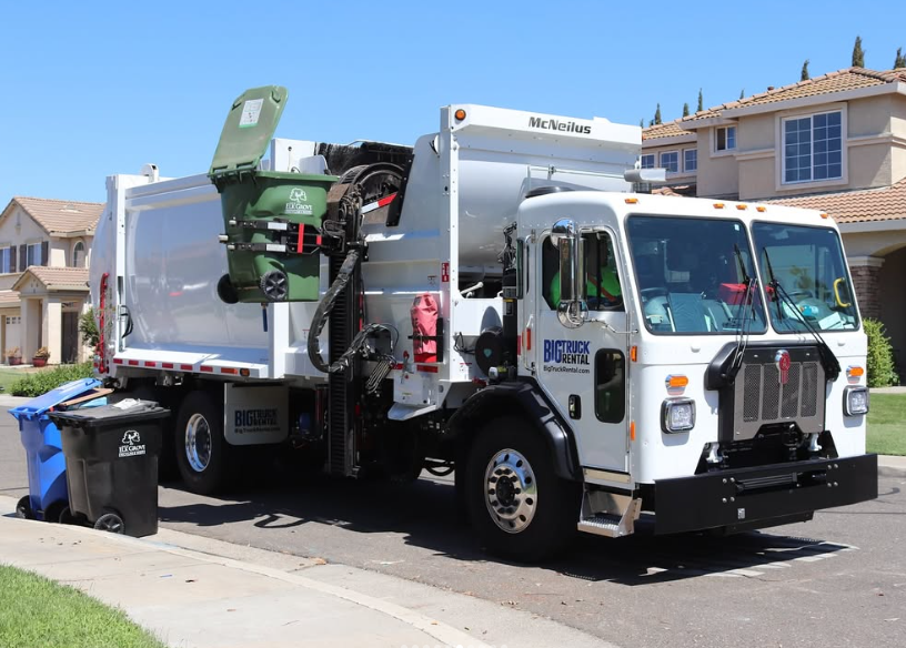 big truck rental side loader operating in residential neighborhood