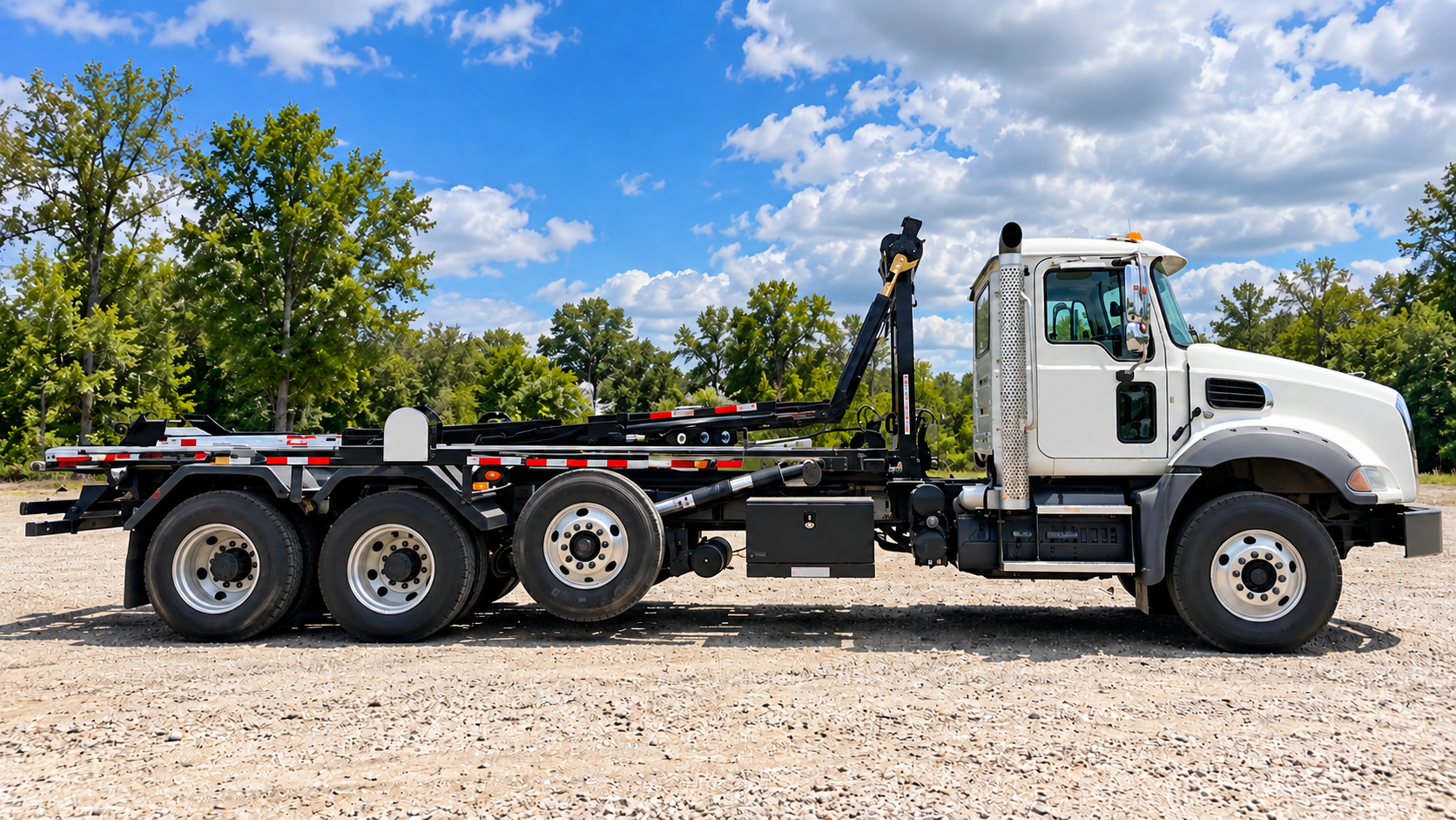 Roll-Off truck parked in gravel lot for sale